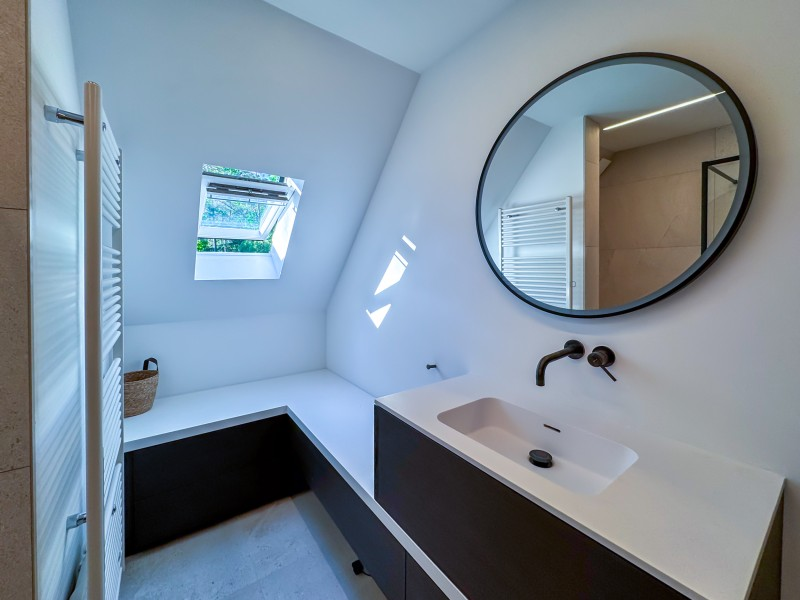 Zolderbadkamer met ronde spiegel en maatwerk